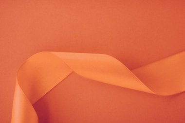 Turuncu arka planda soyut kıvrımlı ipek kurdele, özel lüks.