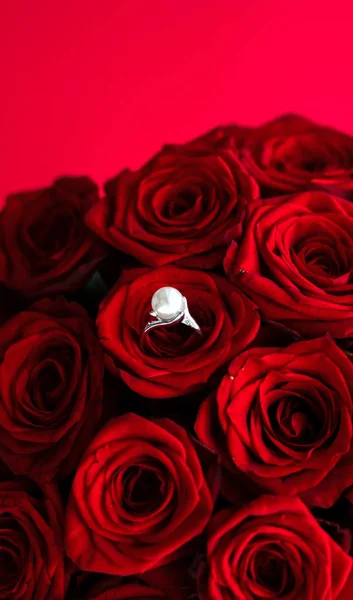 Όμορφο λευκό χρυσό μαργαριτάρι δαχτυλίδι και μπουκέτο από κόκκινα τριαντάφυλλα, πολυτέλεια — Φωτογραφία Αρχείου
