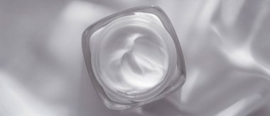 İpek arka planda yüz kremi nemlendirici kavanozu, nemlendirici cilt