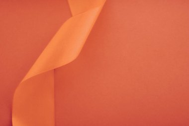 Turuncu arka planda soyut kıvrımlı ipek kurdele, özel lüks.