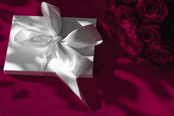 Luxo feriado caixa de presente de seda e buquê de rosas no vinho backgr — Fotografia de Stock