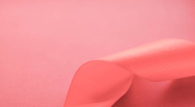 Mercan zemin üzerinde soyut kıvrımlı ipek kurdele, özel lüks.