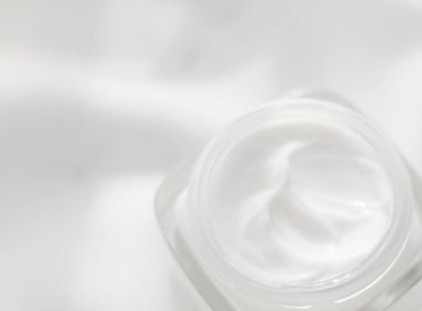 İpek arka planda yüz kremi nemlendirici kavanozu, nemlendirici cilt