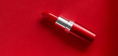 Kırmızı tatil arka planında lüks ruj ve ipek kurdele,-