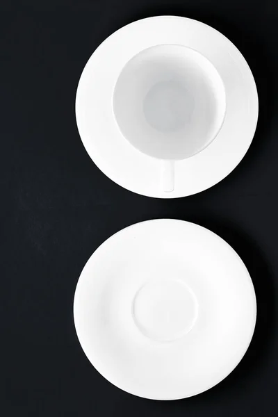 Ensemble de vaisselle en vaisselle blanche, tasse vide sur fond plat noir — Photo