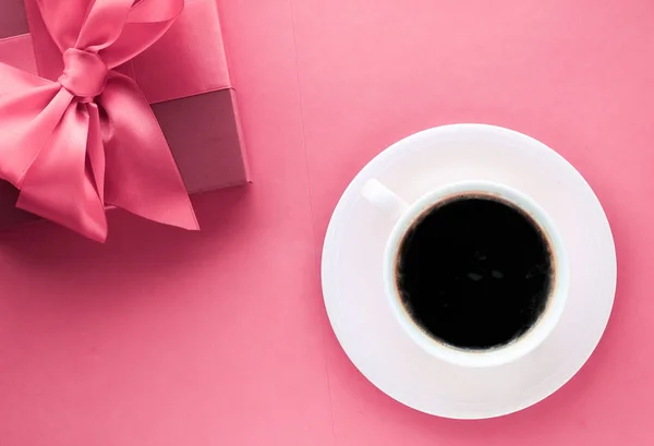 Luksusowe pudełko na prezent i filiżankę kawy na różowym tle, flatlay desig — Zdjęcie stockowe