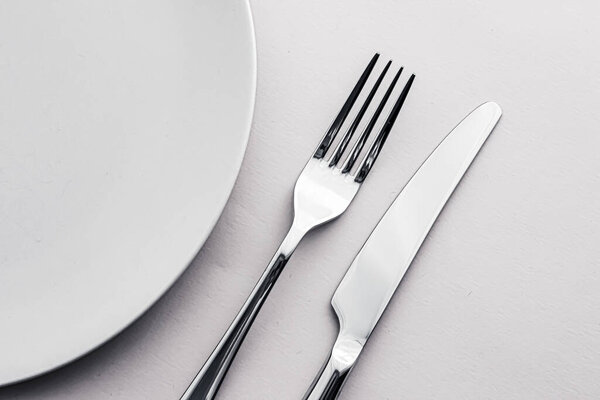 Empty plate and cutlery as mockup set on white background, top tableware for chef table decor and menu branding