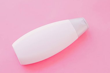 Pembe arka planda boş etiket şampuan şişesi veya duş jeli, güzellik ürünü ve vücut bakım ürünleri