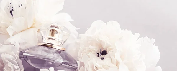 Veilchenduftflasche als Luxus-Parfümprodukt auf Hintergrund von Pfingstrosenblumen, Parfümwerbung und Beauty Branding — Stockfoto