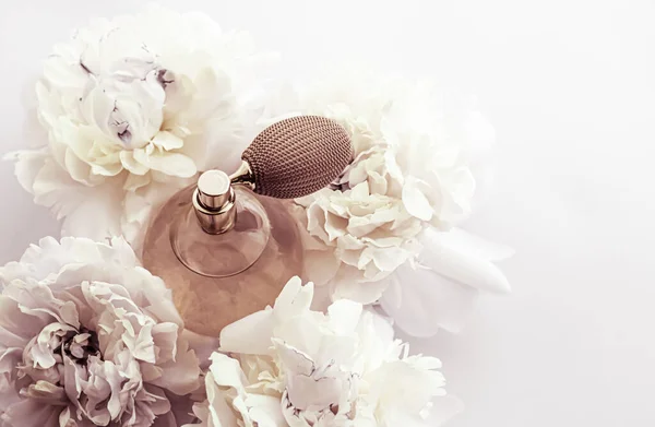 Retro-Parfümflasche als Luxus-Parfümprodukt vor dem Hintergrund von Pfingstrosenblüten, Parfumwerbung und Beauty-Branding — Stockfoto