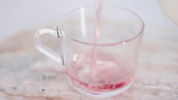 Ζεστό κόκκινο τσάι φρούτων σε γυάλινο κύπελλο στο μαρμάρινο πέτρινο τραπέζι, οργανικό ποτό και ποτό — Αρχείο Βίντεο
