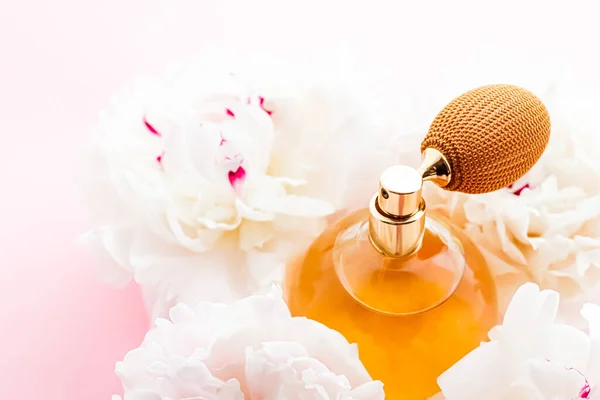 Шикарная бутылка аромата в качестве цитрусового парфюмерного продукта на фоне пионских цветов, парфюмерной рекламы и брендинга красоты — стоковое фото