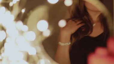 Siyah gece elbisesi giyen bir kadın lüks elmas mücevherler, insanlar ve tatiller sergiliyor.