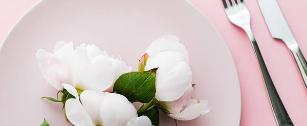 Placa de comedor y cubiertos con flores de peonía como decoración de la boda sobre fondo rosa, vajilla superior para la decoración del evento y la marca de menú —  Fotos de Stock