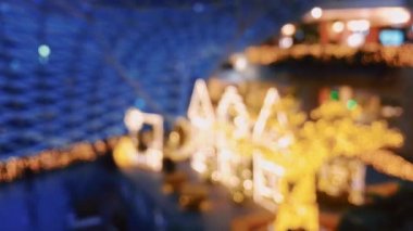 Modern alışveriş merkezindeki Noel dekorasyonunun, arka planının ve aydınlanmasının odaklı olmayan görüntüsü