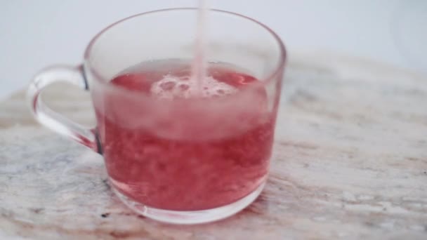 Thé aux fruits rouges chauds dans une tasse en verre sur une table en pierre de marbre, boisson biologique et boisson 