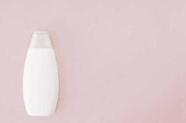 Pembe arka planda boş etiket şampuan şişesi veya duş jeli, güzellik ürünü ve vücut bakım ürünleri