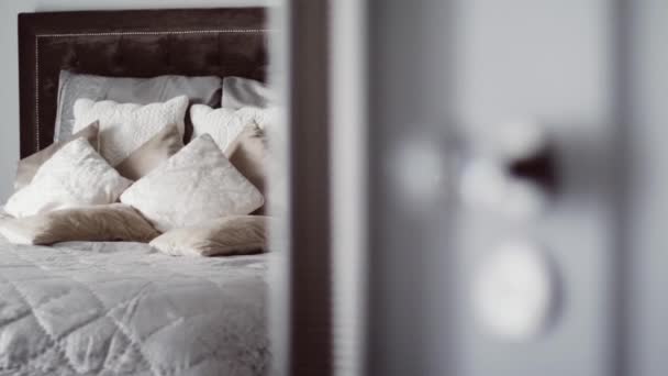 Cojines decorativos y almohadas en la cama en un interior de dormitorio de lujo, puerta abierta a la habitación, decoración del hogar y diseño — Vídeos de Stock