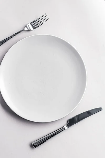 Placa vazia e talheres como mockup definido no fundo branco, utensílios de mesa superior para decoração de mesa de chef e marca de menu — Fotografia de Stock