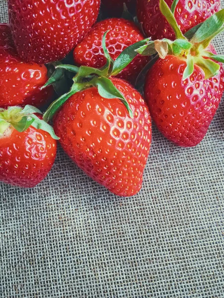 Bio-Erdbeeren auf rustikalem Leinenhintergrund — Stockfoto