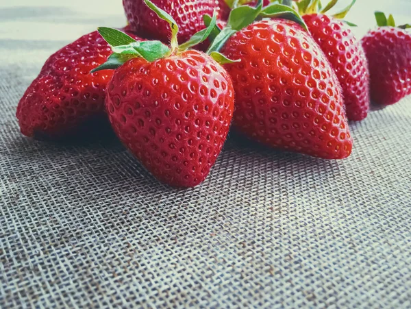 Bio-Erdbeeren auf rustikalem Leinenhintergrund — Stockfoto