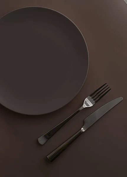Placa vazia e talheres como mockup definido no fundo marrom escuro, utensílios de mesa superior para decoração de mesa chef e marca de menu — Fotografia de Stock