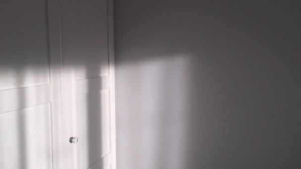Drzwi białe eleganckie szafy z kryształowymi uchwytami w pokoju o zachodzie słońca, meble i wystrój wnętrz — Wideo stockowe