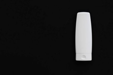 Siyah arkaplanda ürün modeli olarak boş etiket kozmetik kutu şişesi