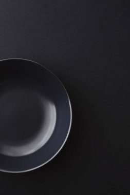 Siyah arka planda boş tabaklar, bayram yemeği için kaliteli bulaşık takımı, minimal tasarım ve diyet