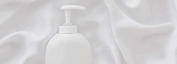 Üres címke kozmetikai tartály üveg mint termék mockup fehér selyem háttér — Stock Fotó