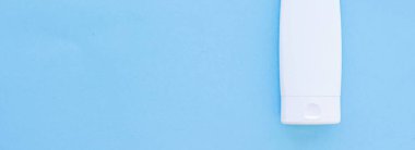 Mavi arkaplanda ürün modeli olarak boş etiket kozmetik kutu şişesi