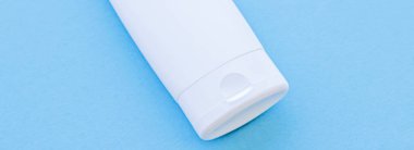 Mavi arkaplanda ürün modeli olarak boş etiket kozmetik kutu şişesi