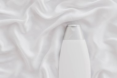 Beyaz ipek arka planda ürün modeli olarak boş etiket kozmetik kutu şişesi