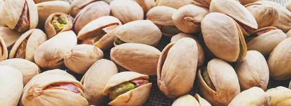 Pistachio nuts on rustic linen background — Stock Photo, Image