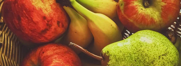 Szerves alma, körte és banán rusztikus alapon fonott kosárban — Stock Fotó
