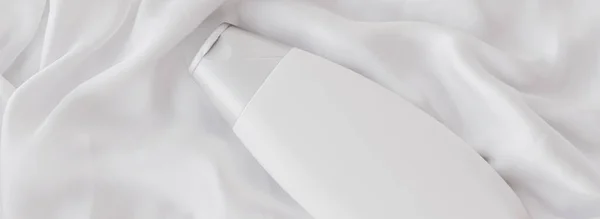 Blanco etiket cosmetische container fles als product mockup op witte zijde achtergrond — Stockfoto