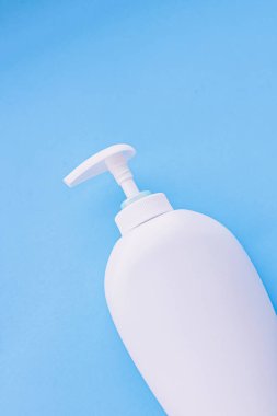 Mavi arkaplanda ürün modeli olarak boş etiket kozmetik kutu şişesi