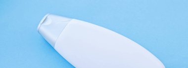 Mavi arkaplanda ürün modeli olarak boş etiket kozmetik kutu şişesi