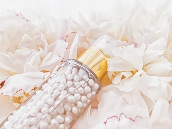 Luxuriöse Kosmetikflasche als Anti-Aging-Pflegeprodukt auf dem Hintergrund von Blumen, leere Etikettenverpackungen für das Körperpflege-Branding — Stockfoto