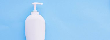 Mavi arkaplanda ürün modeli olarak boş etiket kozmetik kutu şişesi