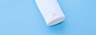 Mavi arkaplanda ürün modeli olarak boş etiket kozmetik kutu şişesi