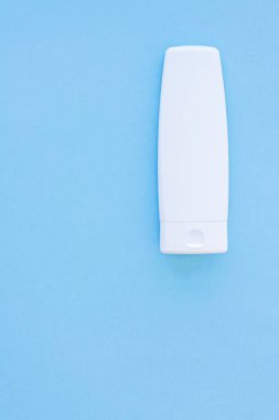 Mavi arkaplanda ürün modeli olarak boş etiket kozmetik kutu şişesi