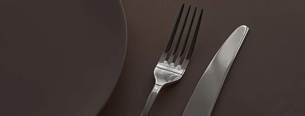 Placa vazia e talheres como mockup definido no fundo marrom escuro, utensílios de mesa superior para decoração de mesa chef e marca de menu — Fotografia de Stock