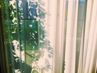 Gün batımında penceredeki perdeler