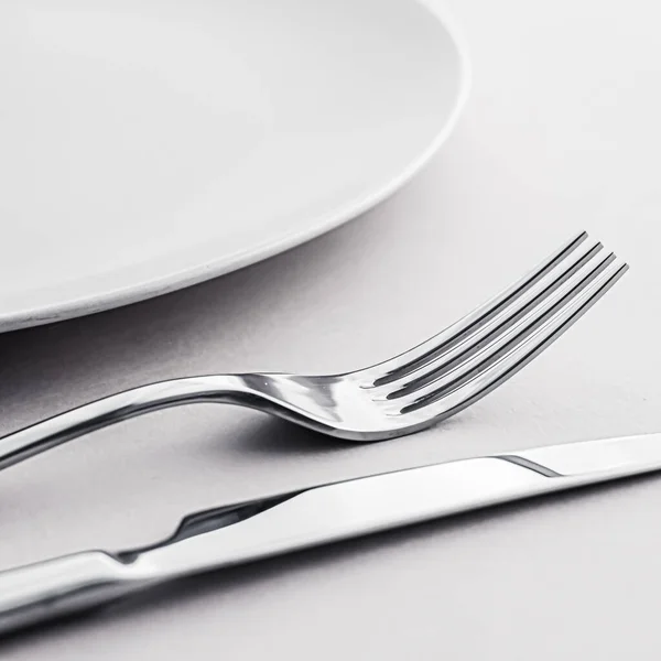 Placa vacía y cubiertos como juego de maquetas sobre fondo blanco, vajilla superior para la decoración de la mesa del chef y la marca del menú —  Fotos de Stock