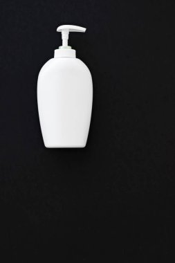 Siyah arkaplanda ürün modeli olarak boş etiket kozmetik kutu şişesi