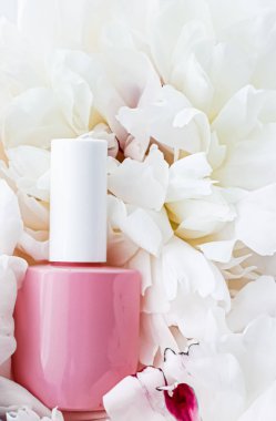 Çiçek arka planında tırnak cilası şişeleri, Fransız manikürü ve kozmetik marka.