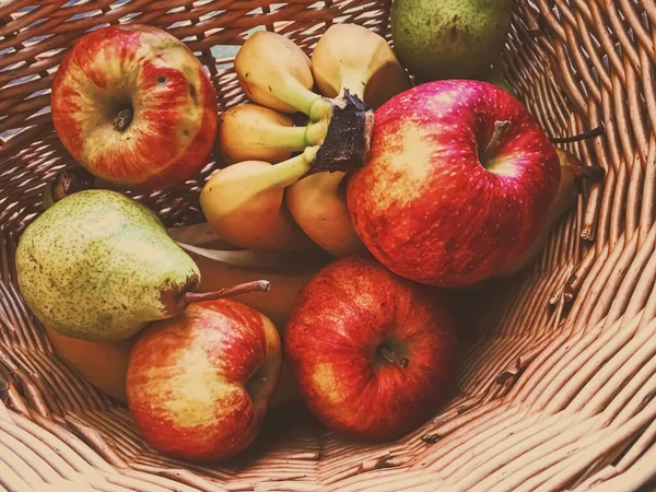 Hasır bir sepette organik elmalar, armutlar ve muzlar — Stok fotoğraf