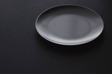 Siyah arka planda boş tabaklar, bayram yemeği için kaliteli bulaşık takımı, minimal tasarım ve diyet