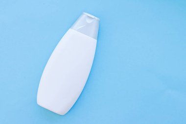 Mavi arkaplanda ürün modeli olarak boş etiket kozmetik kutu şişesi